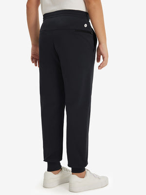 Model's lower body from the back, wearing black fleece stretch water resistant boys joggers.