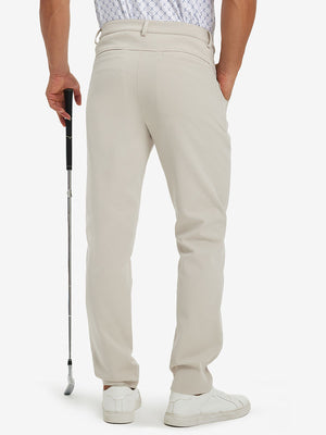 Back lower-body view of lightweight moisture wicking dress pants, model with golf club in light khaki.