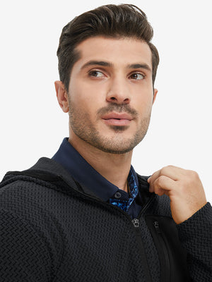 Model holding collar with one hand, wearing full zip fleece hoodied jacket in black.