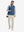 Model carrying a tennis bag, wearing cream soft lightweight casual golf pants with 5 pockets.