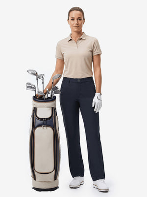 Front full body shot of model with golf gear wearing navy women's regular fit stretchy golf pants