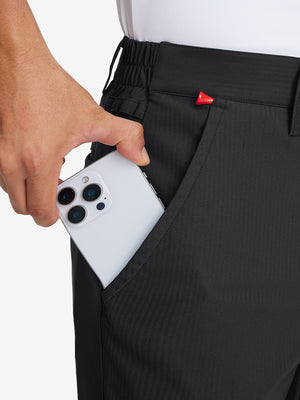 Hand placing an iPhone into pocket of lightweight flat front casual trousers in black.