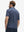Back half-body view of model wearing the dark blue golf club 4 way stretch print collared polo shirt, highlighting the rear silhouette