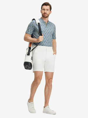 Full front: model in blue abstract stretch printed collarless henley golf shirts with golf bag.