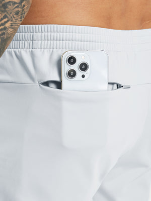 Back pocket detail of Water Resistant Comfy Fleece Golf Joggers in misty grey, holding smartphone