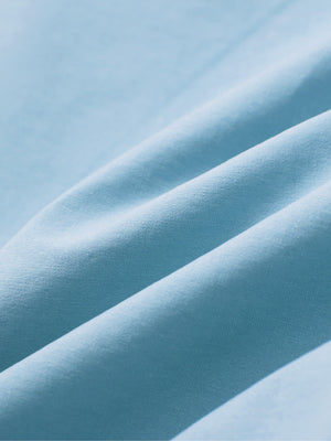 Close-up of sky blue boys lightweight dry fit flat front golf shorts fabric texture.