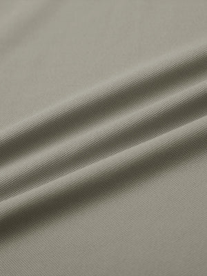 Close-up of dark khaki long sleeve solid jersey polo fabric texture showing soft knit and smooth finish details.