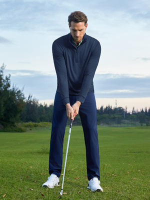 Model preparing to swing on course, wearing quarter zip melange pullover in cobalt heather with sporty look