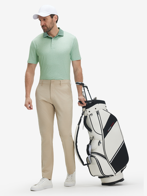 Full front: model in green abstract lightweight stretch upgraded print golf polo shirts holding golf bag.
